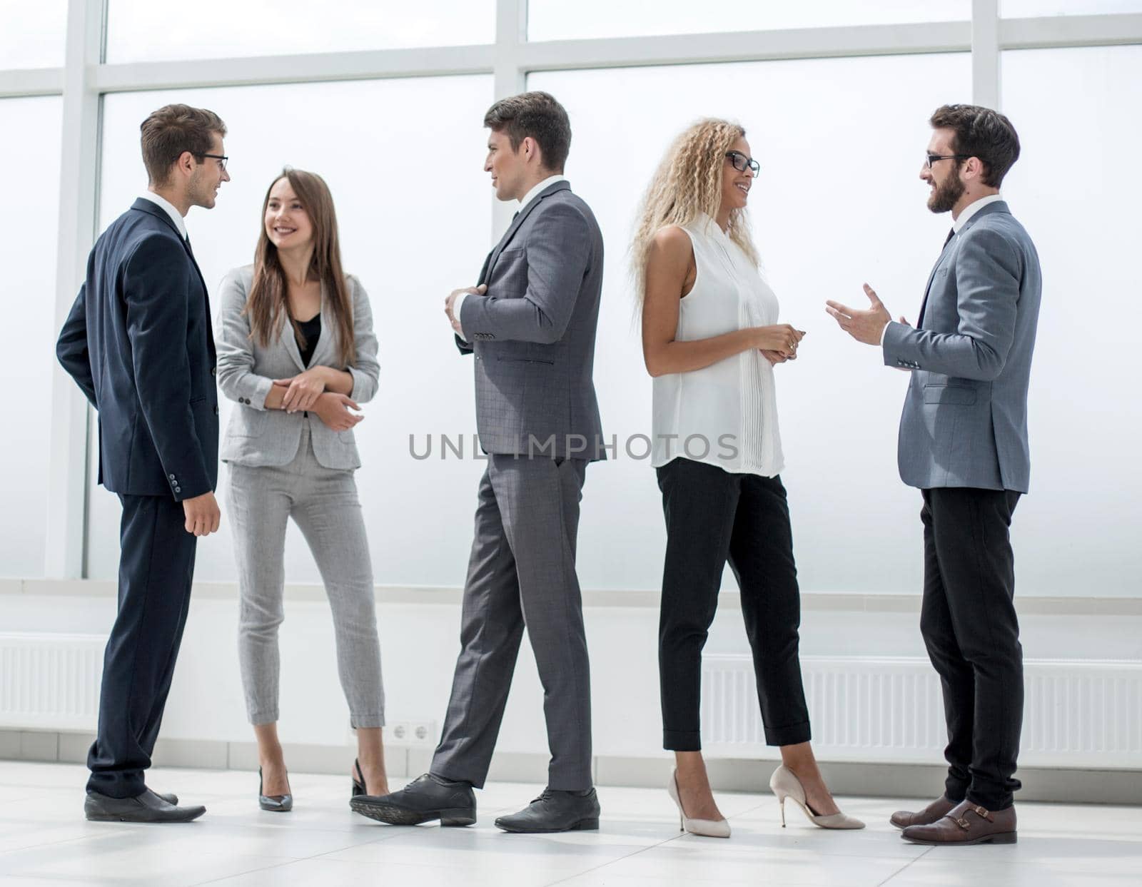 in full growth.a group of business people talking in the lobby of the office.photo with copy space