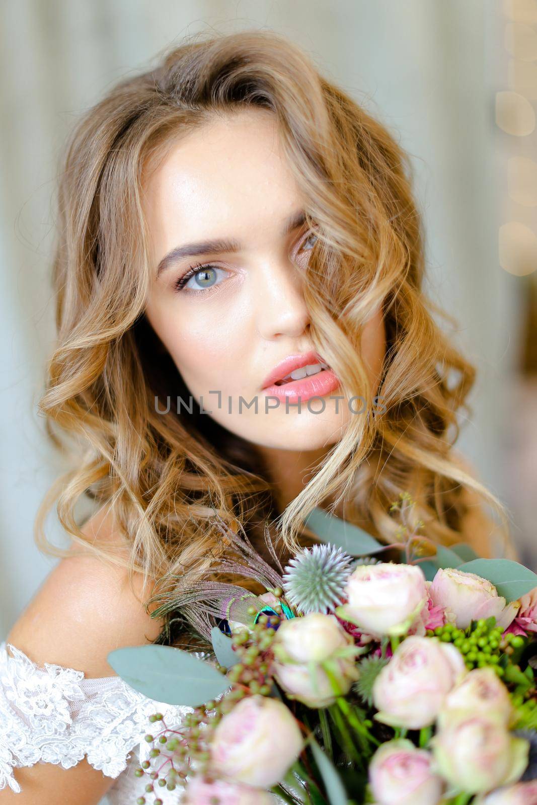 Close up portrait of young beautiful caucasian bride with bouquet at studio. Concept of bridal photo session and floristic art.