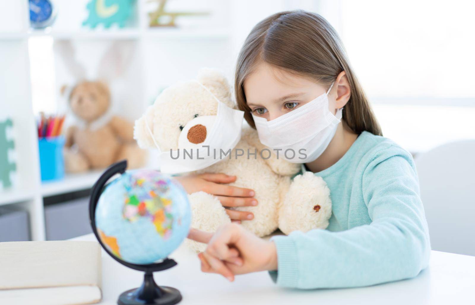 Beautiful school girl with teddy bear studying at home