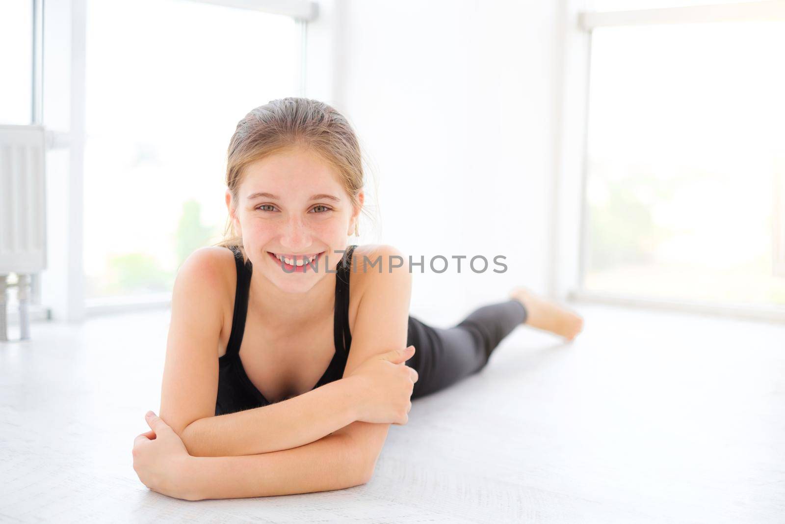 Cute teenager girl lying on a floor in light room