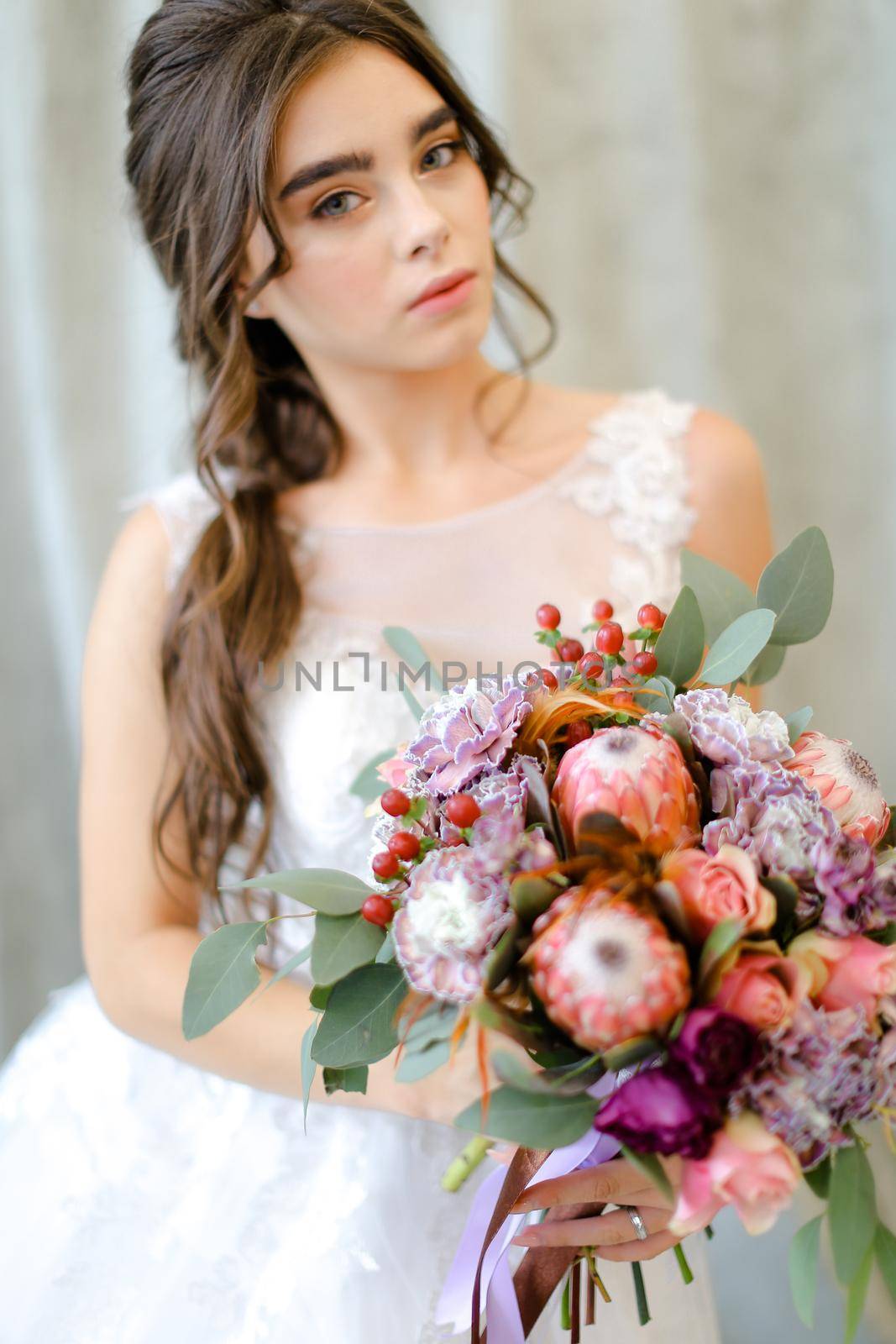 Portrait of young caucasian brunette bride with flowers at photo studio. by sisterspro