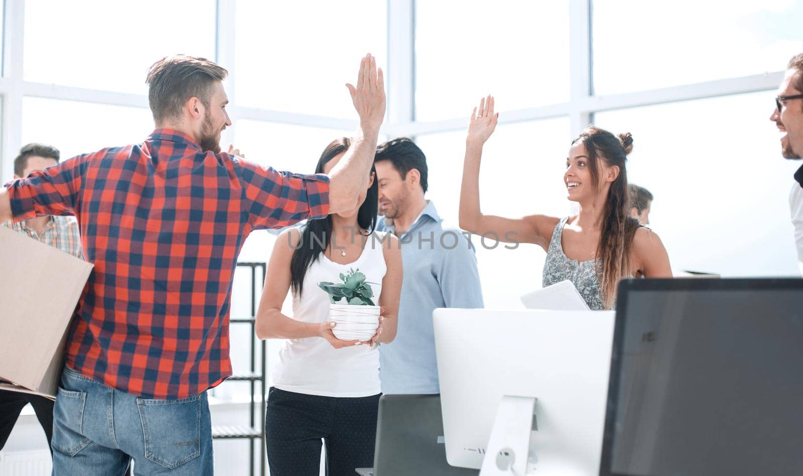 business team is giving each other a high five in the new office by asdf