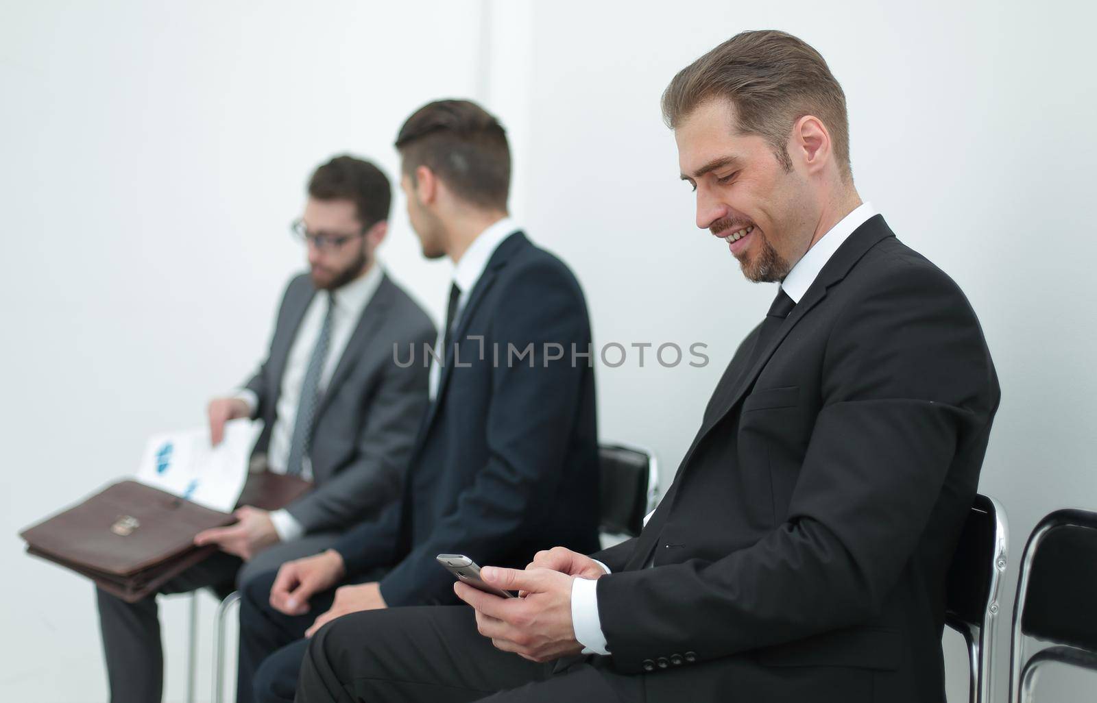 smiling businessman typing SMS on smartphone by asdf