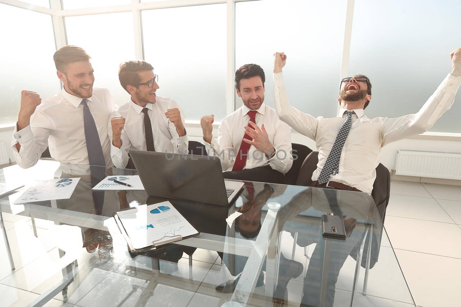 very happy business team sitting at the Desk.the concept of a successful startup