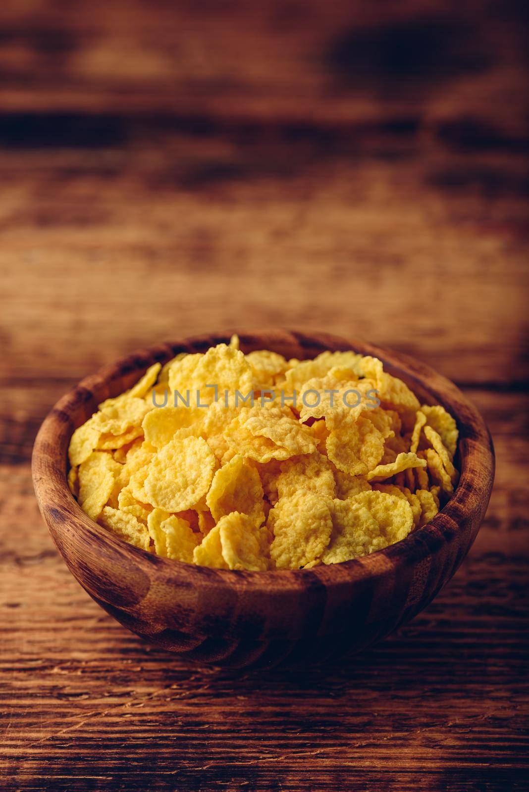 Rustic bowl of corn flakes over wooden surface