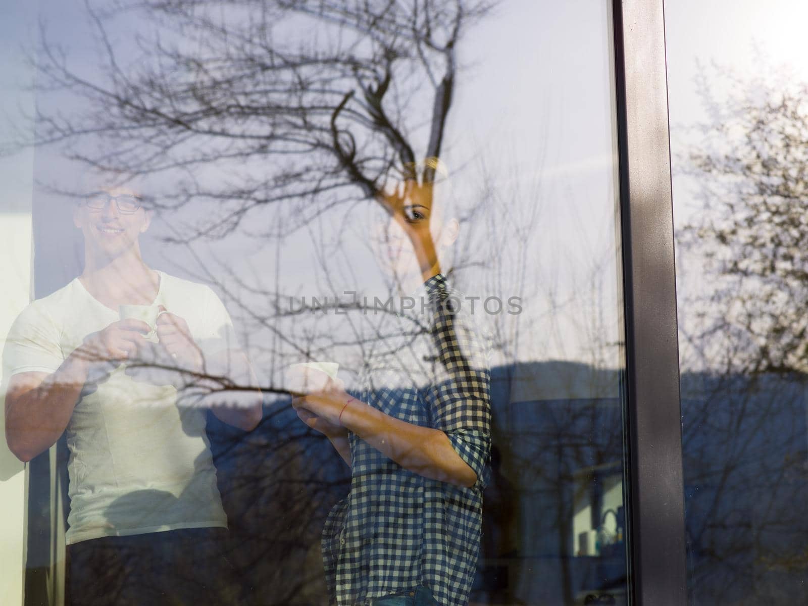 romantic happy young couple enjoying morning coffee by the window in their luxury home