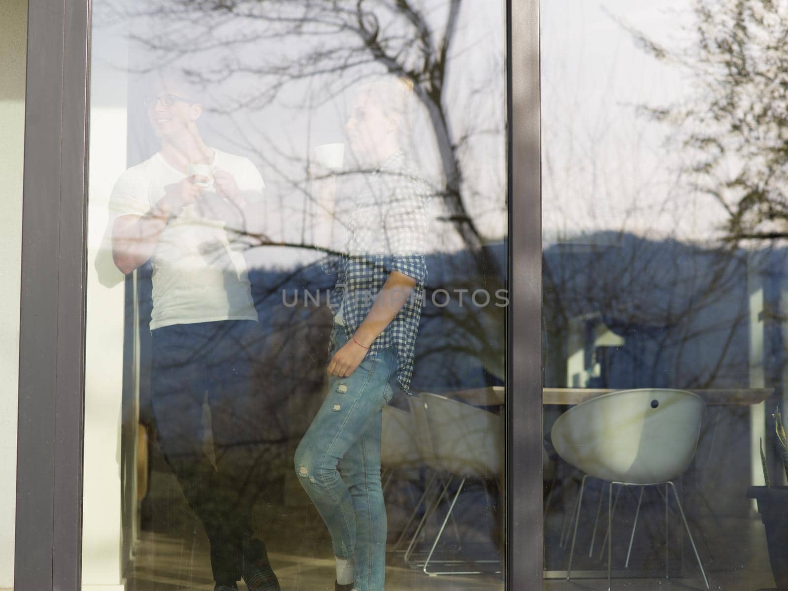 romantic happy young couple enjoying morning coffee by the window in their luxury home