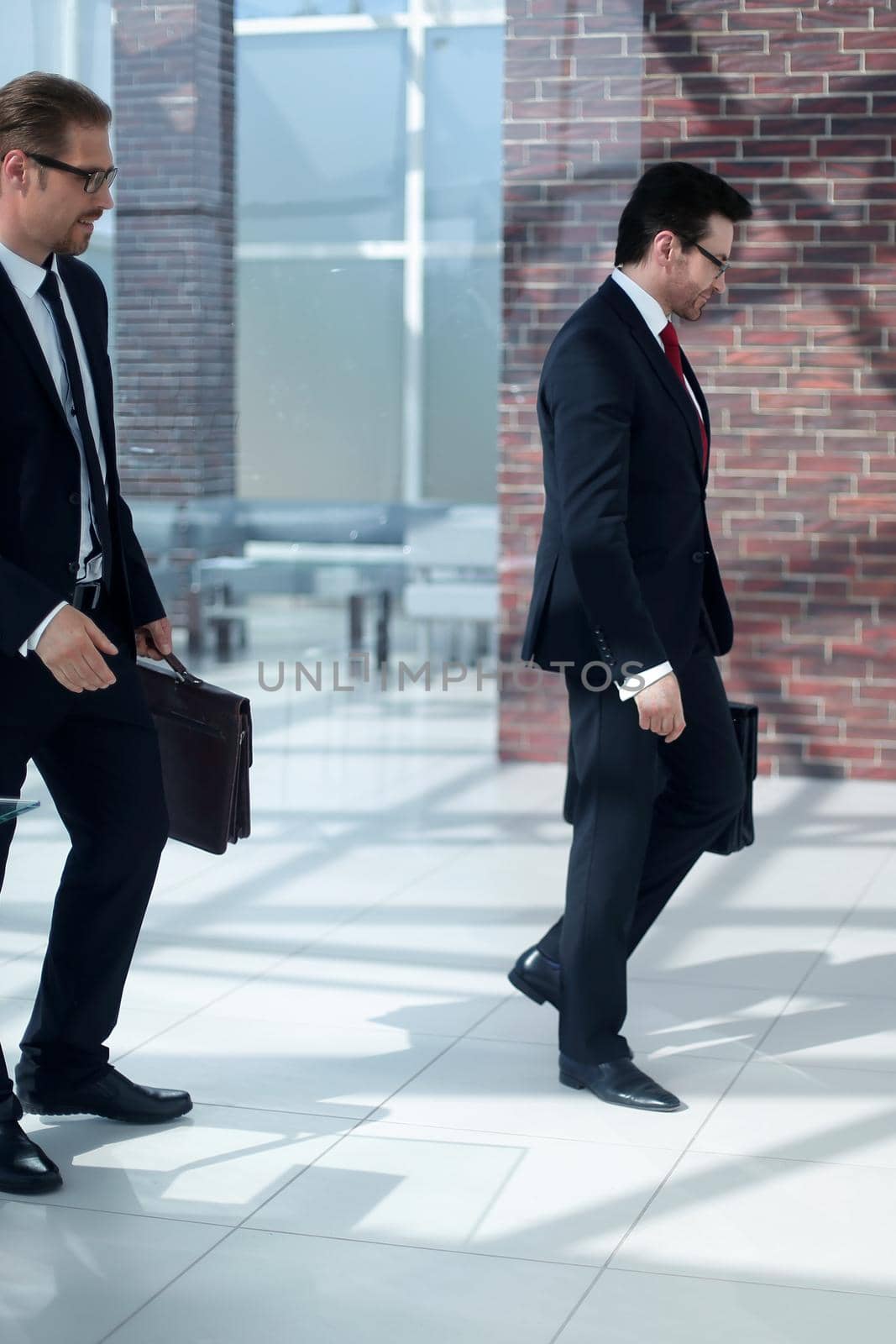Business people walking in the office corridor by asdf