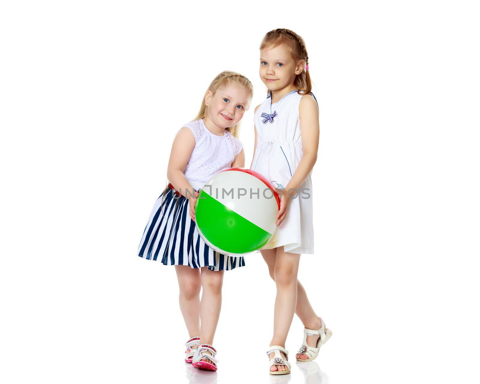 Two little girls are playing with a ball. Game concept, rest on the sea.Isolated on white background.