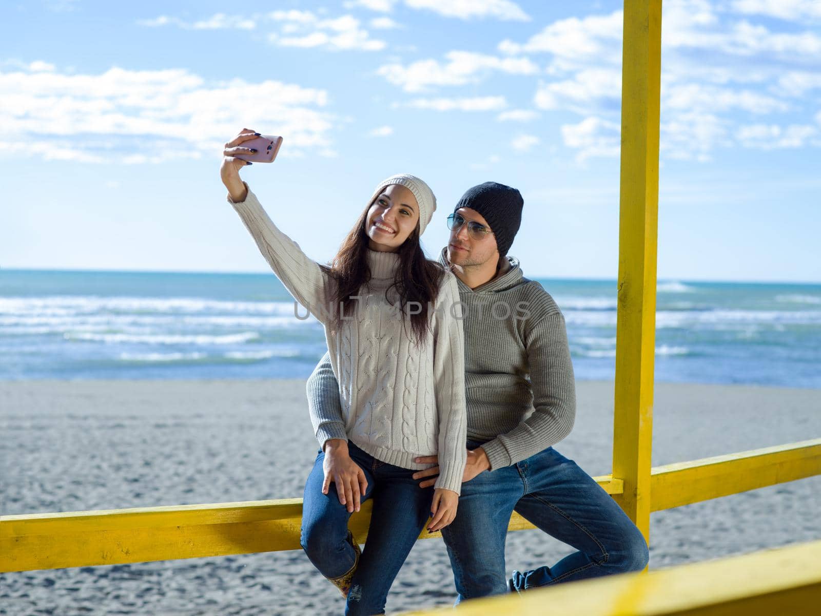 Very Happy Couple In Love Taking Selfie On The Beach in autmun day