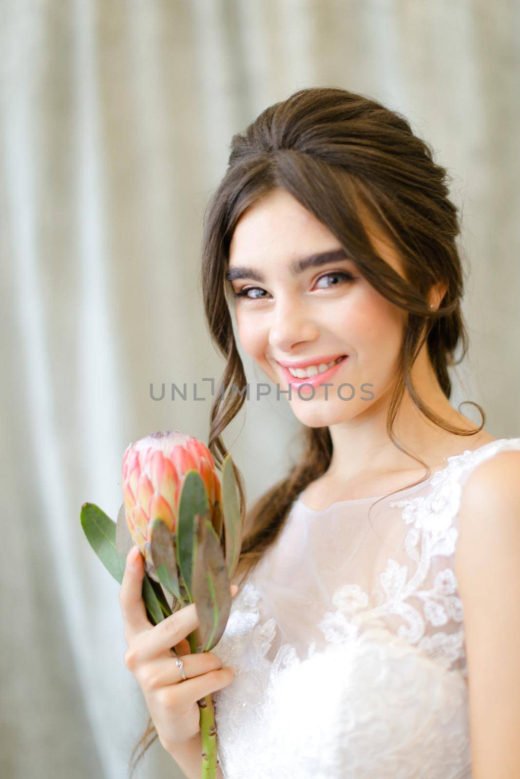 Portrait of smiling caucasian bride with flowers at photo studio. by sisterspro