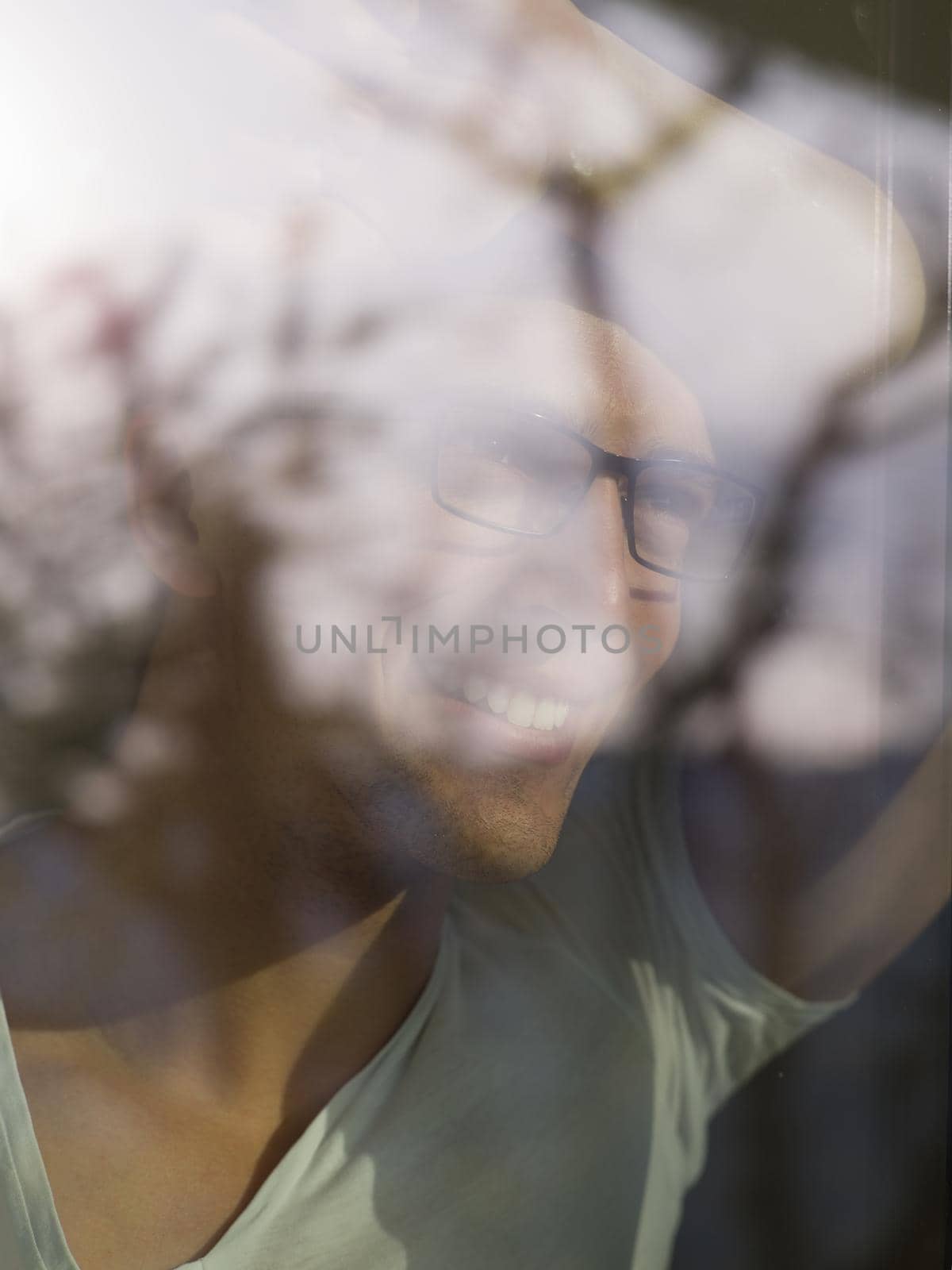 young handsome man drinking morning coffee by the window in his home