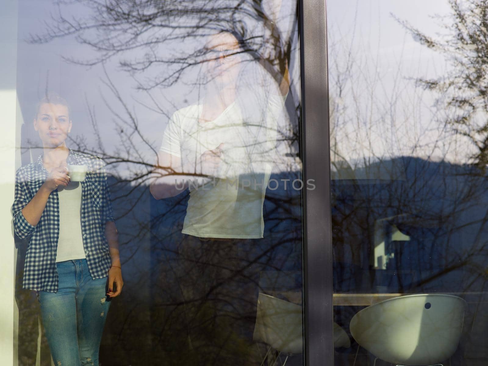 romantic happy young couple enjoying morning coffee by the window in their luxury home