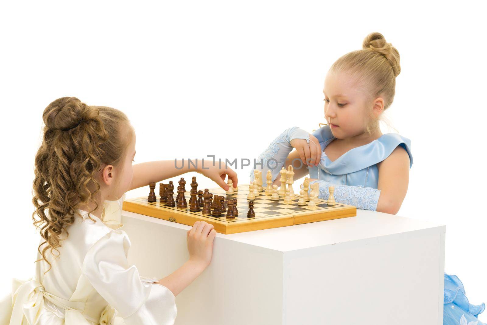 two very reasonable little girls playing chess. Concept of mental development of the child in the family and school. Measurement on a white background.