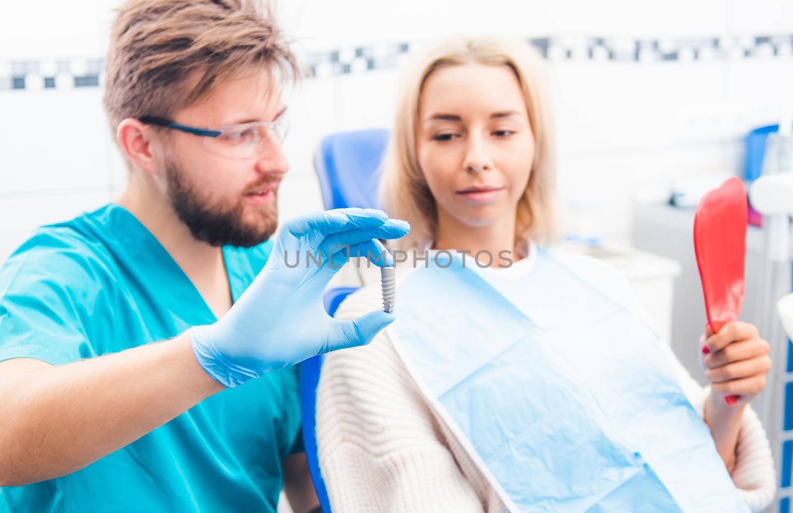 Dentist showing gray implant model by GekaSkr