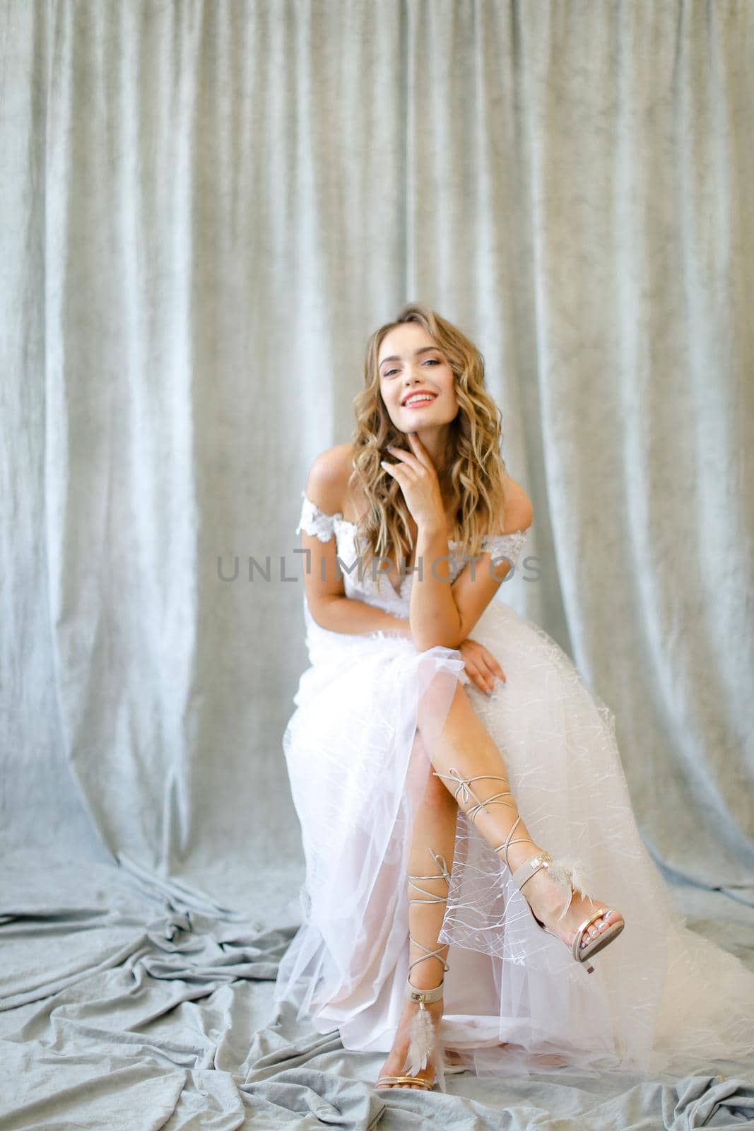 Young pretty bride sitting at studio. Concept of wedding and bridal photo sesion, fashion, nice fiancee.