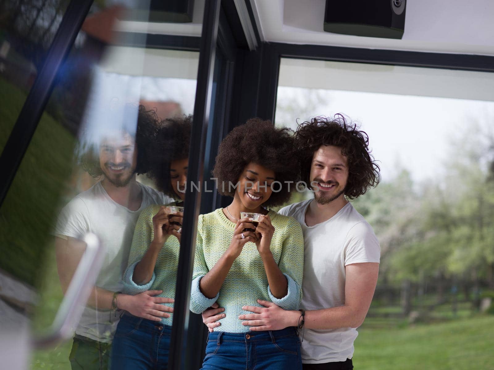 romantic happy young multiethnic couple enjoying morning coffee by the window in their luxury home