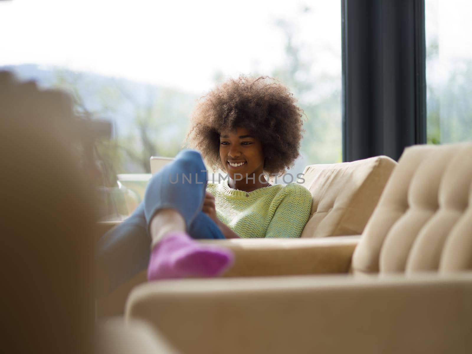 Young african american woman at home relaxing in her luxury lliving room reading a digital tablet  surf internet and work