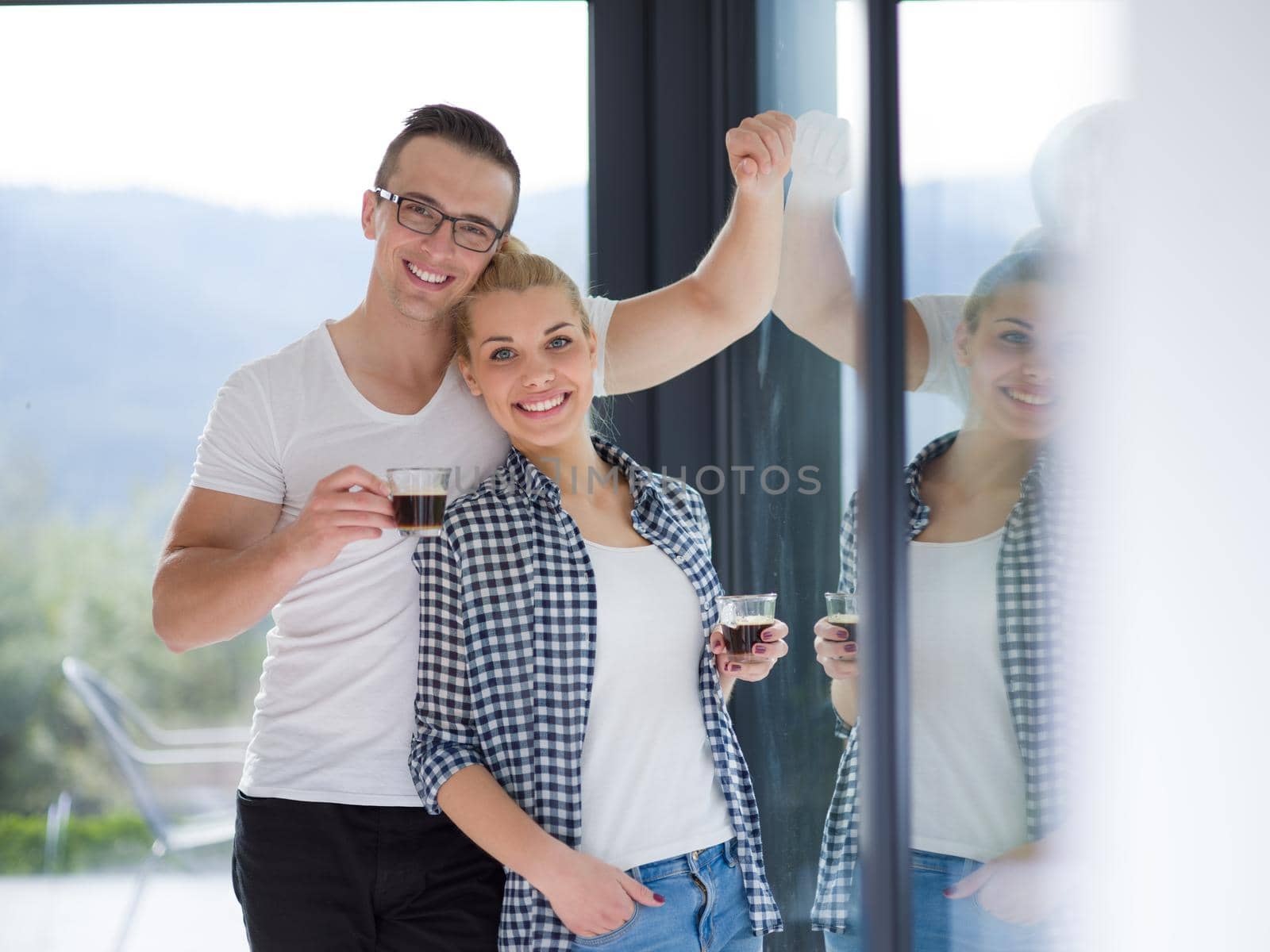 romantic happy young couple enjoying morning coffee by the window in their luxury home