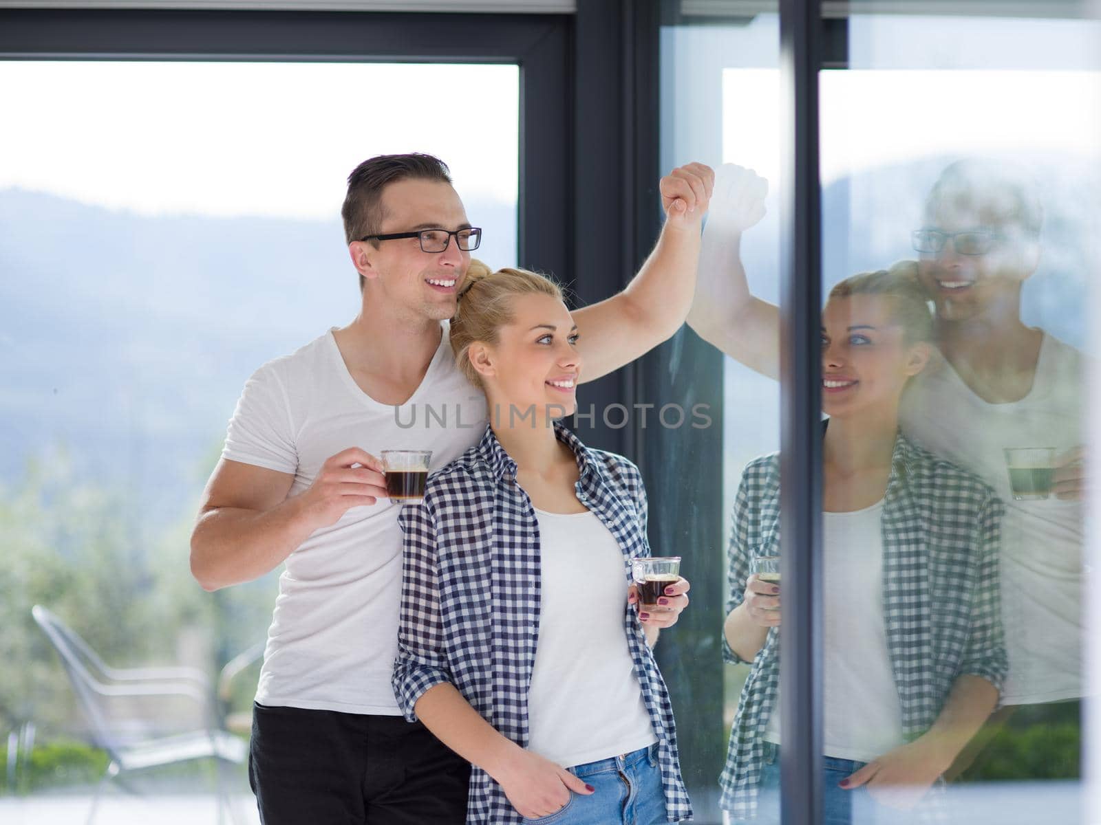 romantic happy young couple enjoying morning coffee by the window in their luxury home