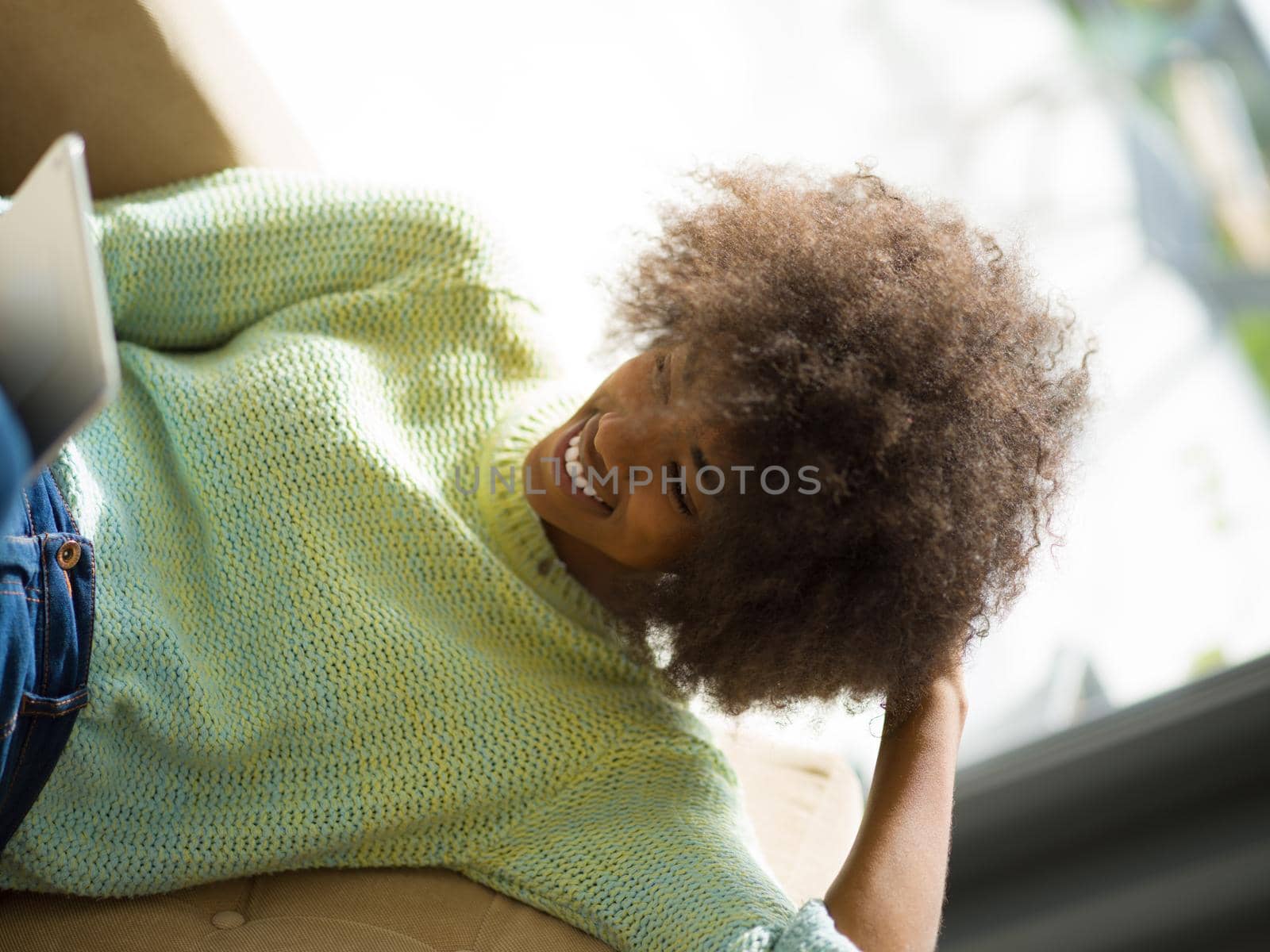 Young african american woman at home relaxing in her luxury lliving room reading a digital tablet  surf internet and work