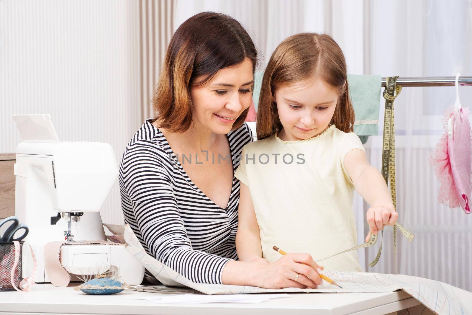 Master seamstress is teaching her pupil how to work with taken measurements