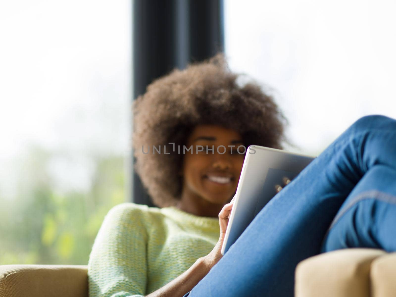 Young african american woman at home relaxing in her luxury lliving room reading a digital tablet  surf internet and work