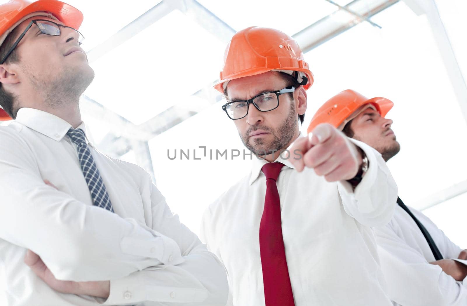close up.a confident businessman in a safety helmet pointing at you.the concept of cooperation