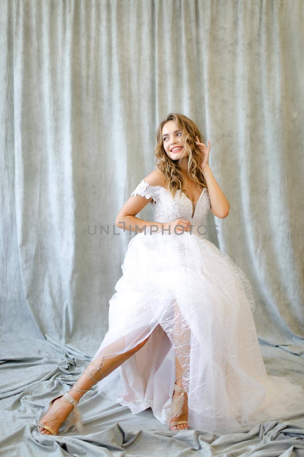 Young blonde caucasian bride sitting at studio. Concept of wedding and bridal photo sesion, fashion, nice fiancee.