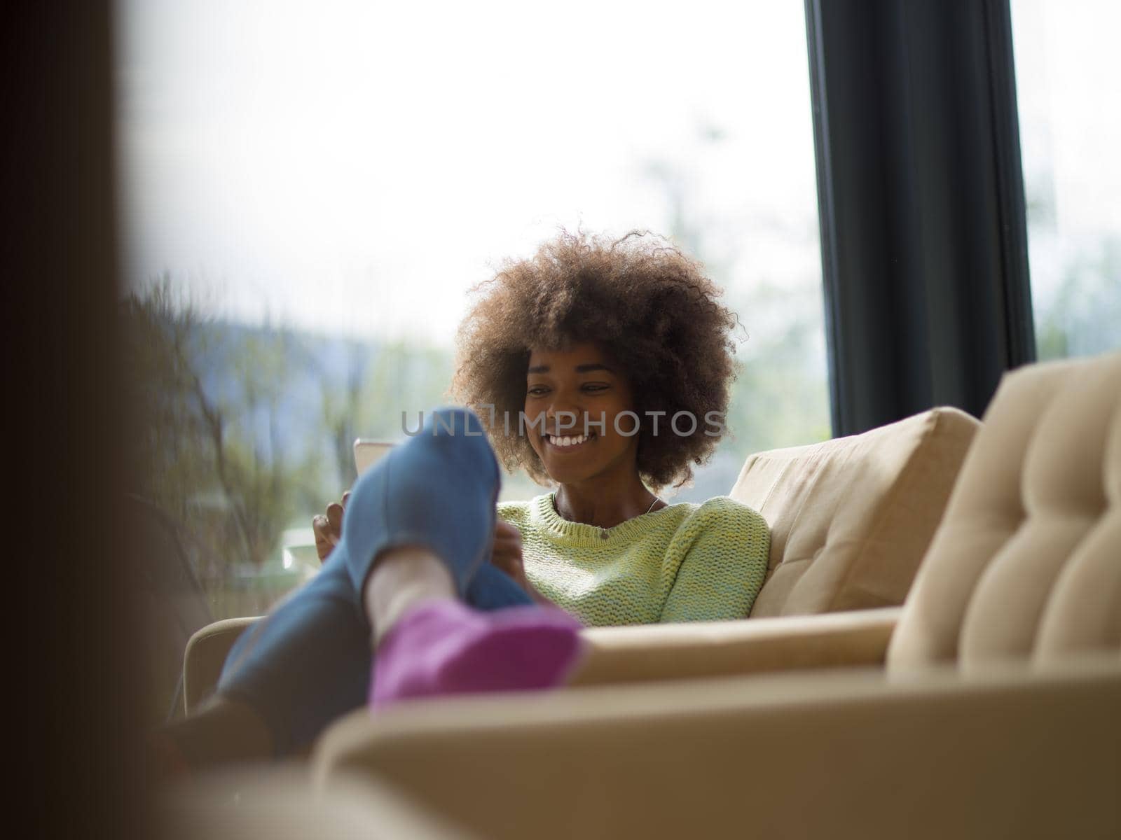Young african american woman at home relaxing in her luxury lliving room reading a digital tablet  surf internet and work