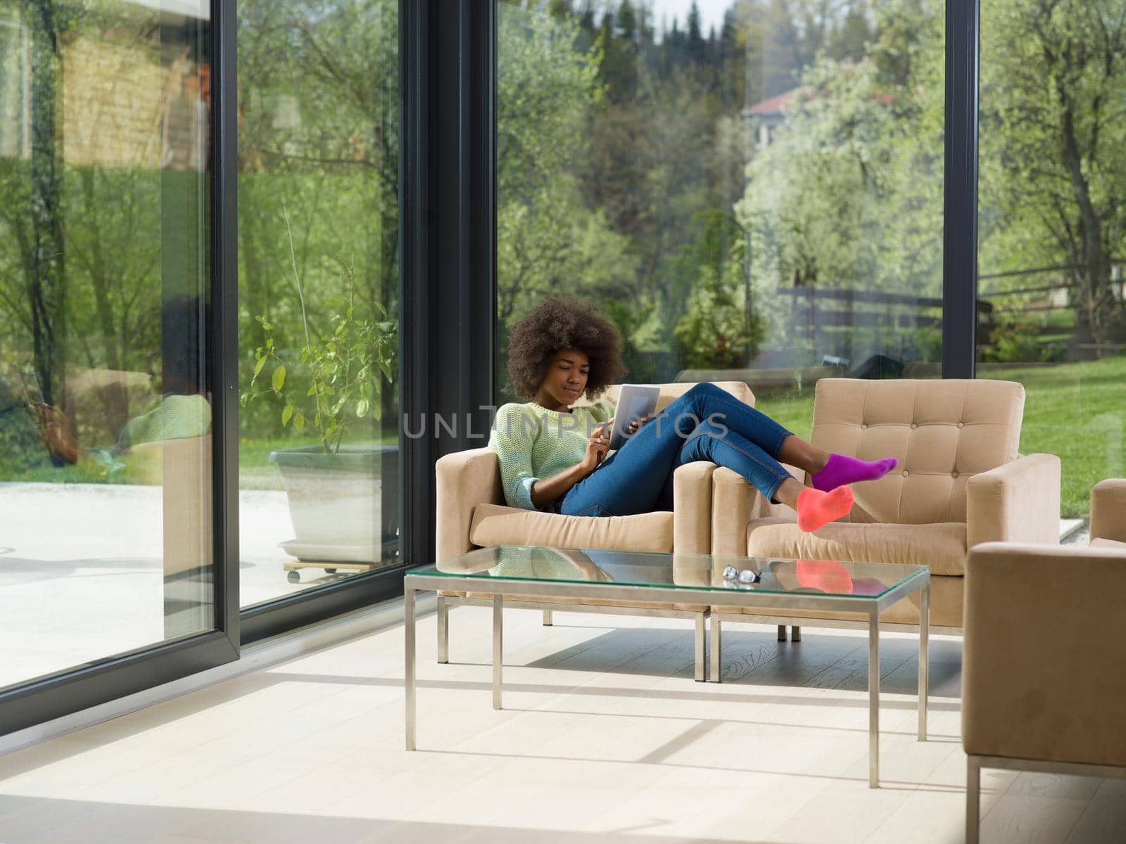 Young african american woman at home relaxing in her luxury lliving room reading a digital tablet  surf internet and work