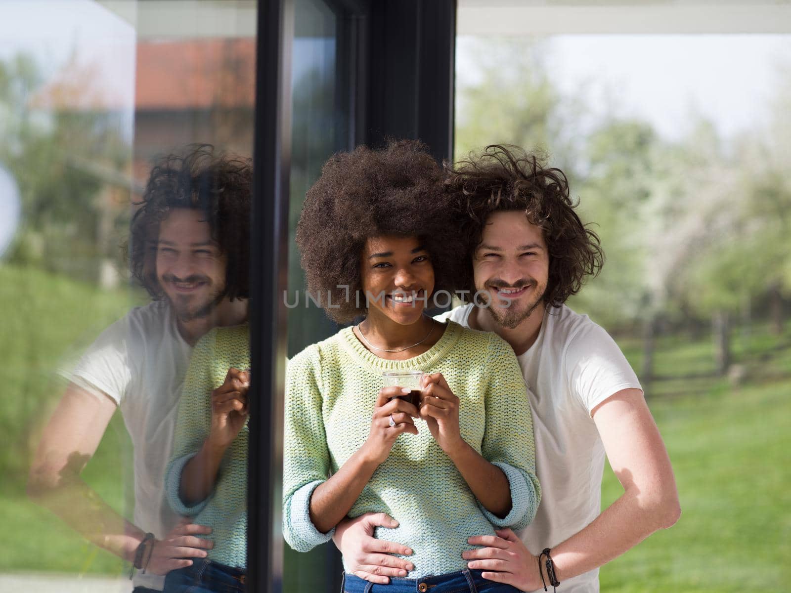 romantic happy young multiethnic couple enjoying morning coffee by the window in their luxury home