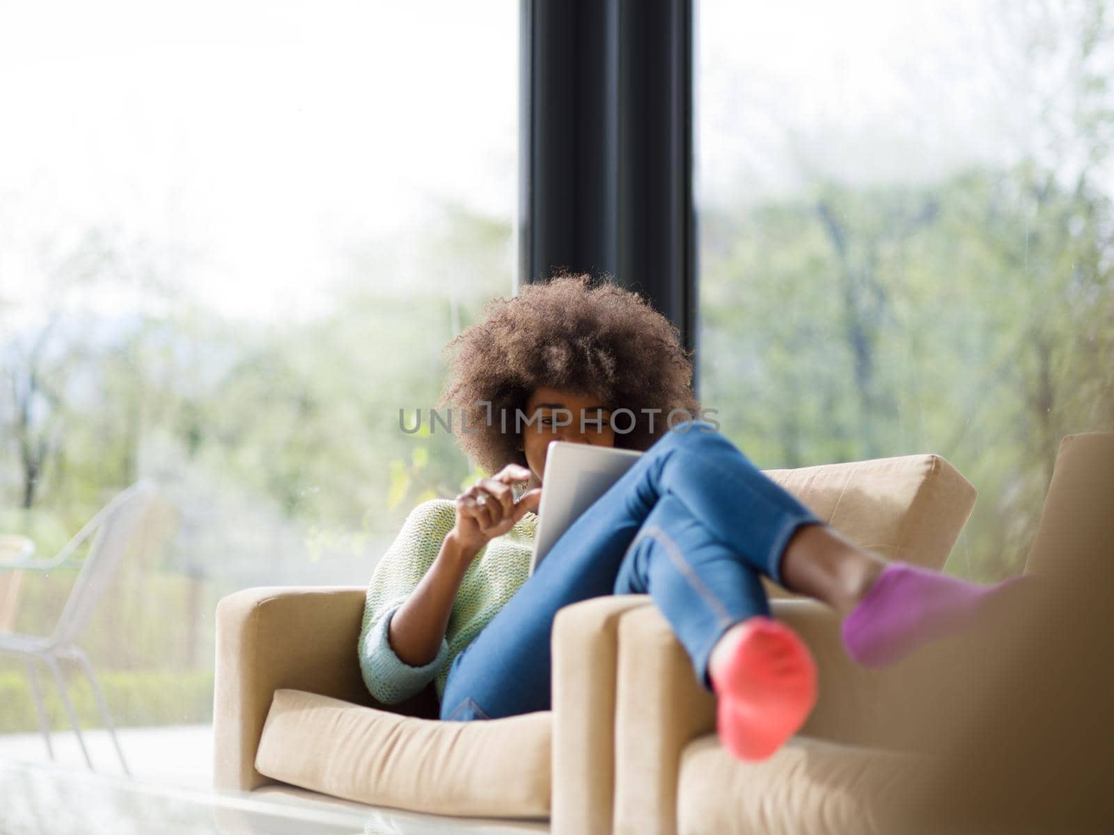 Young african american woman at home relaxing in her luxury lliving room reading a digital tablet  surf internet and work