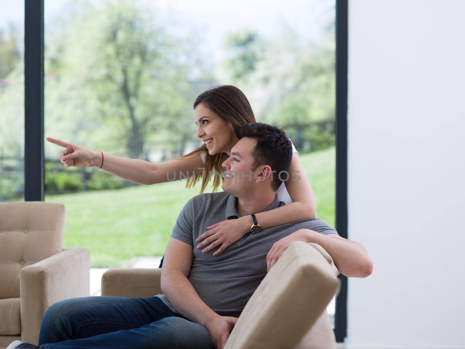 young handsome couple enjoys hugging on the sofa in their luxury home villa