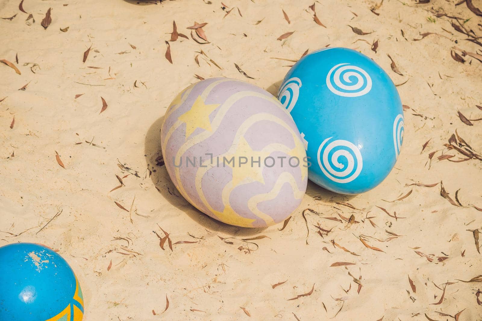 Multicolored eggs in the grass. Easter eggs hunt, outdoors. Celebrating Easter holiday.