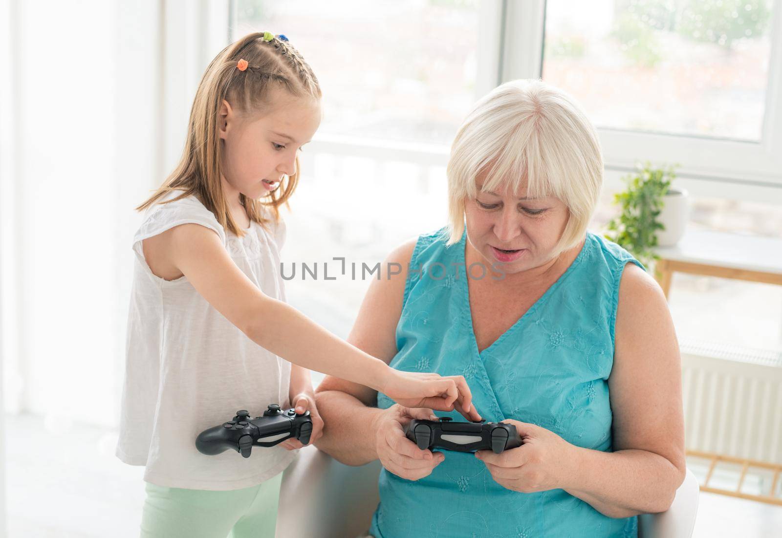 Girl teaching woman to play on joystick by GekaSkr