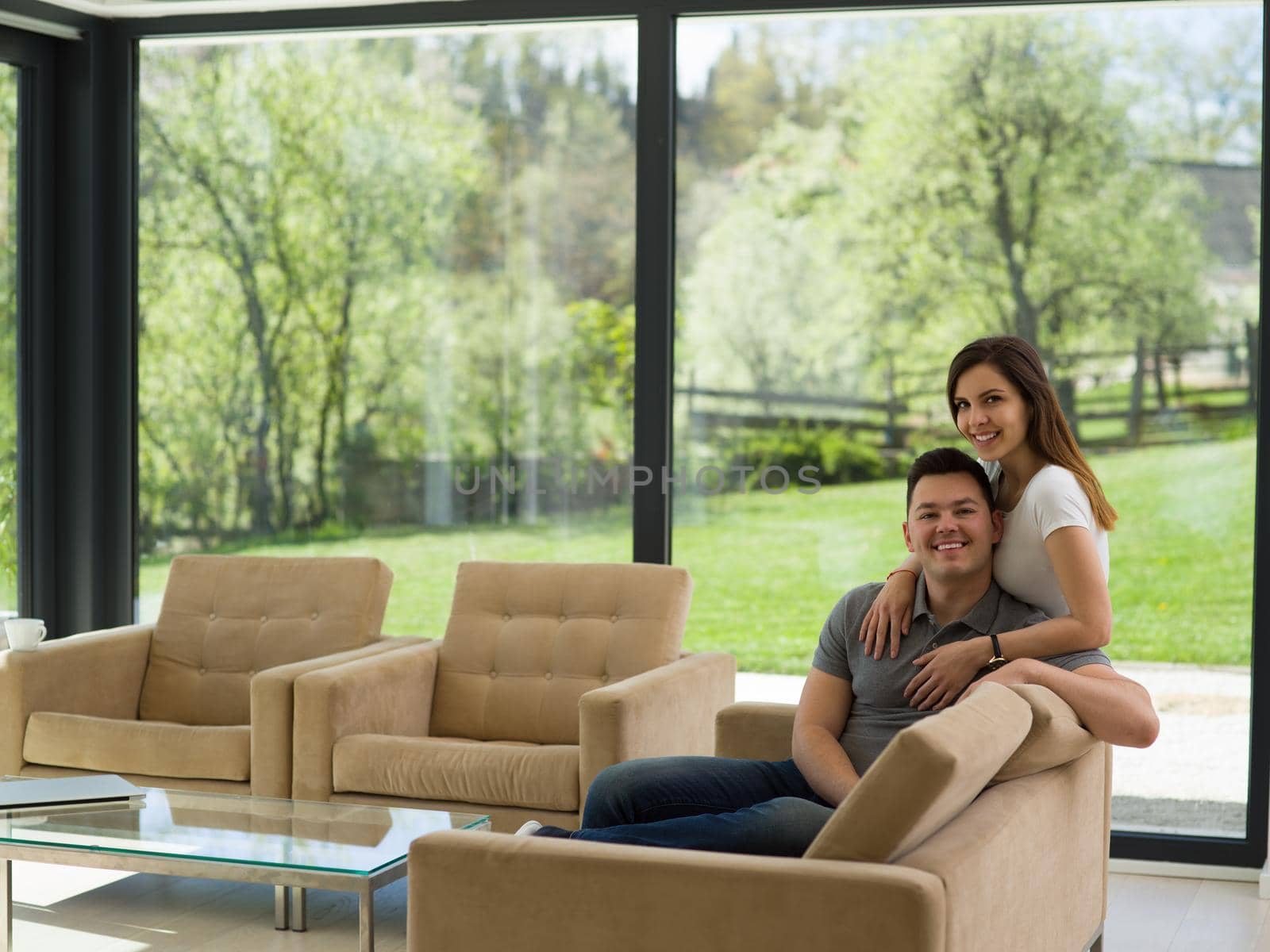 young handsome couple enjoys hugging on the sofa in their luxury home villa