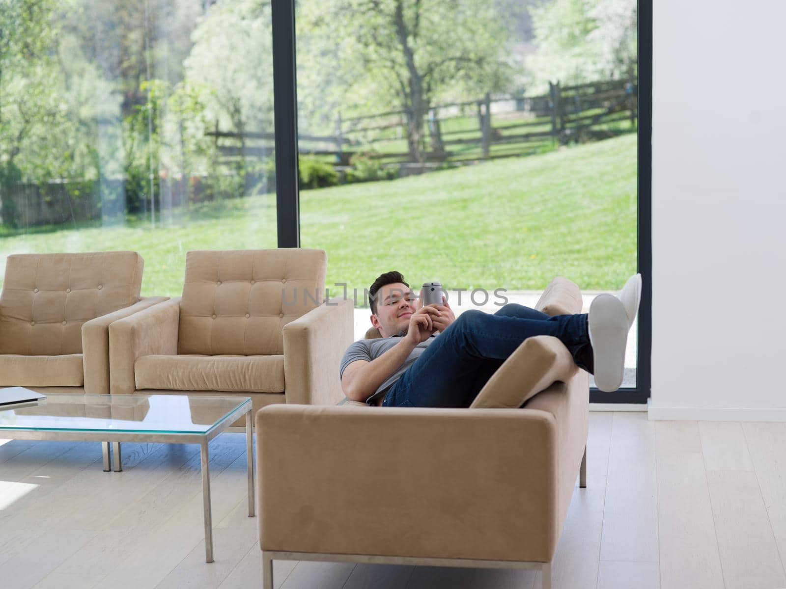 Handsome casual young man using a mobile phone at luxurious home