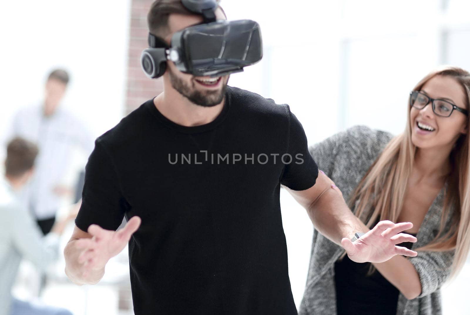 Attractive bearded man enjoyingvirtual reality glasses in modern interior design studio.Home play concept.