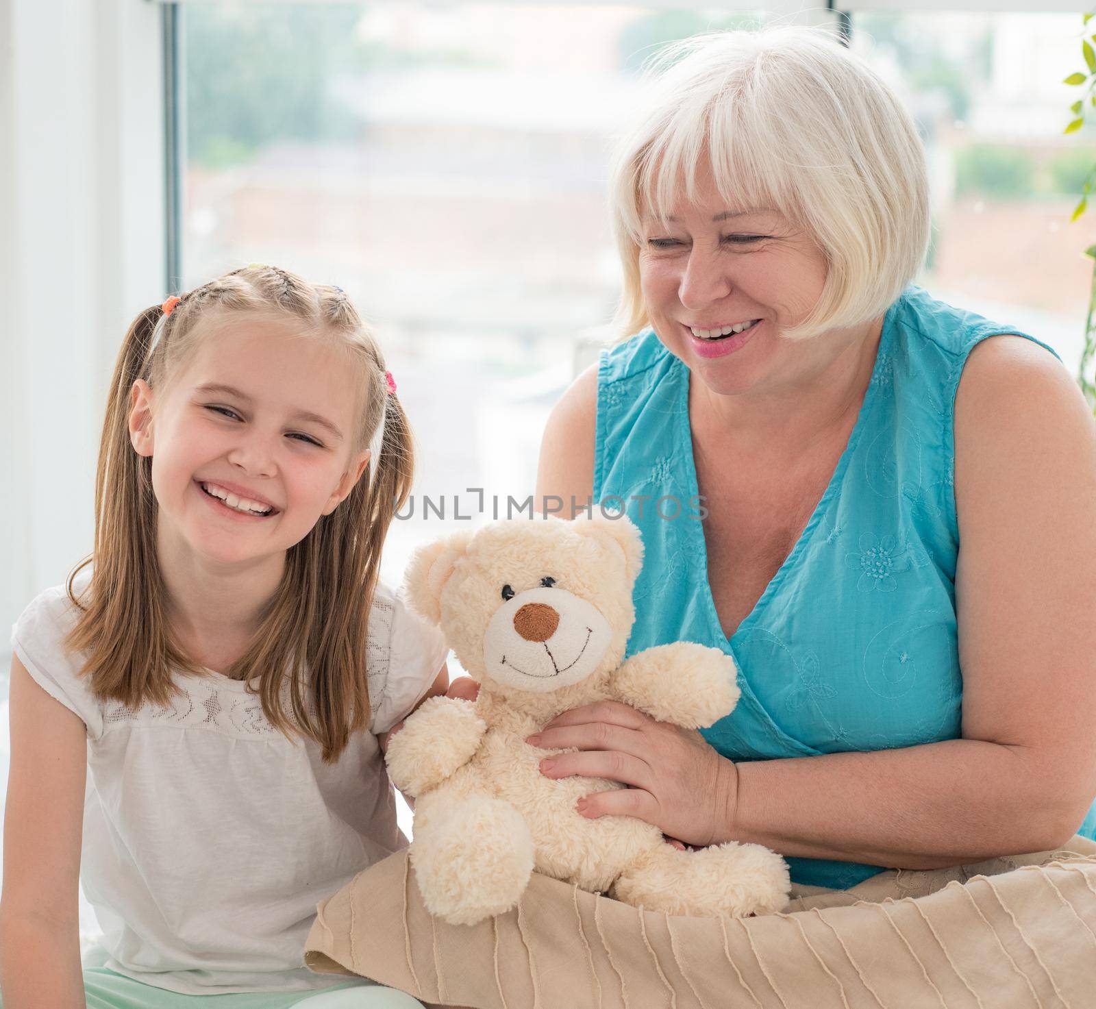 Grandmother and granddaughter playing with plush teddy by GekaSkr