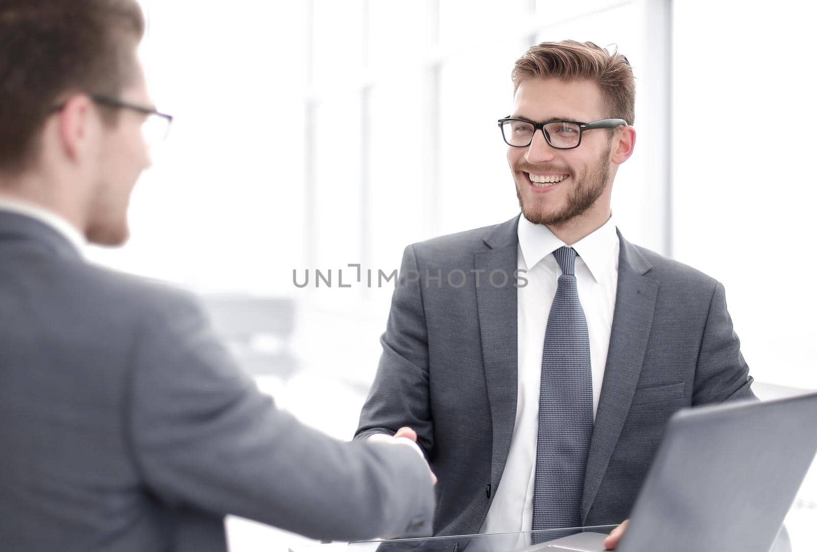 close up.smiling business people shaking hands in office.business concept