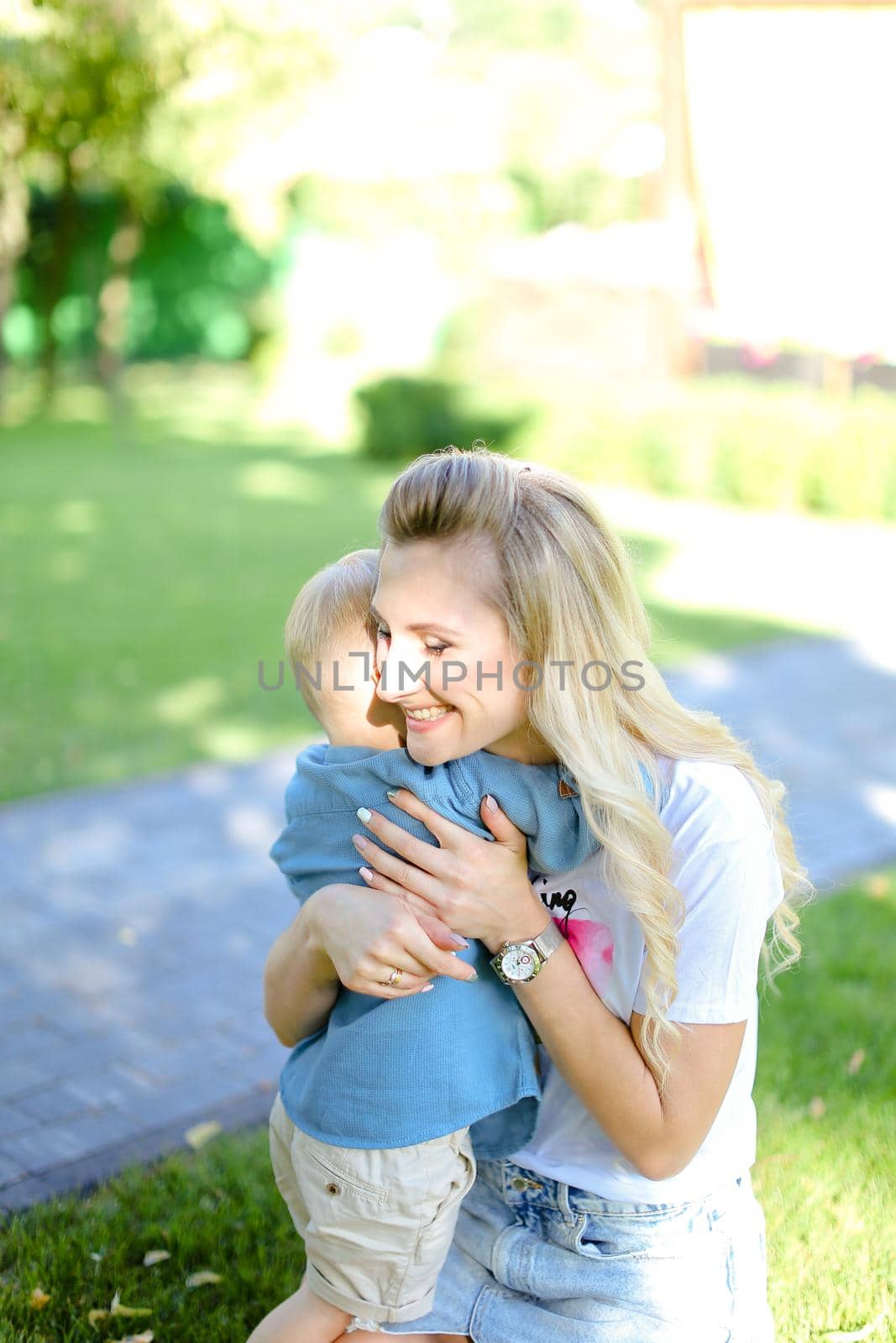 Young blonde mother hugging little son. by sisterspro