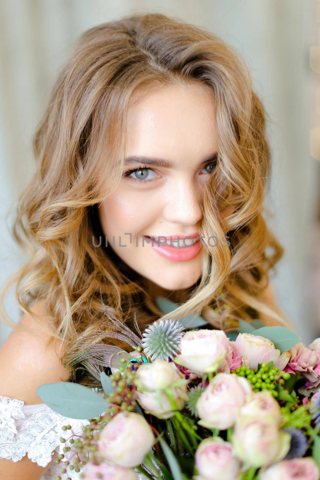 Close up portrait of young bride with bouquet at studio. Concept of bridal photo session and floristic art.