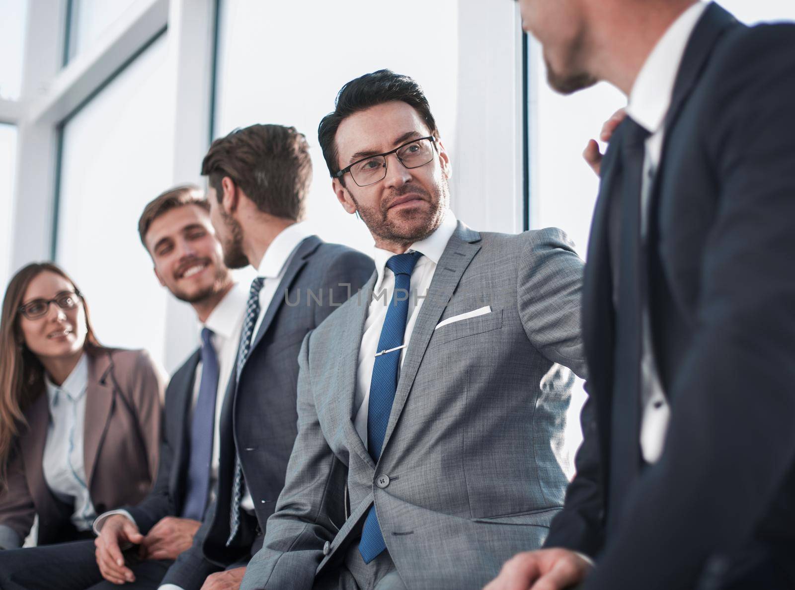 a team of financial managers discussing the annual reports together, meeting together in a modern meeting room with panoramic windows