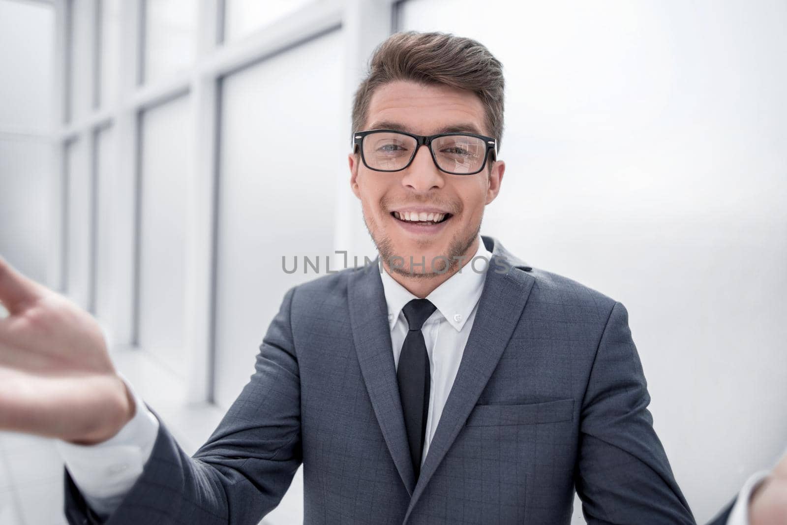 close up.surprised young businessman standing near the window.