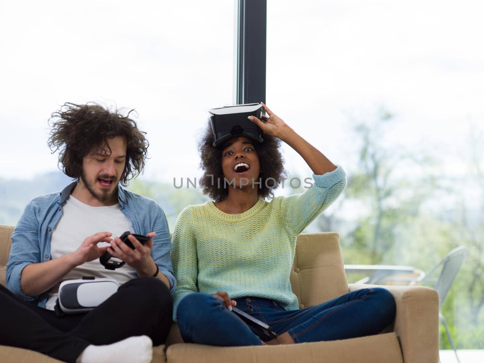 Multiethnic Couple using virtual reality headset in living room at home  people playing game with new trends technology