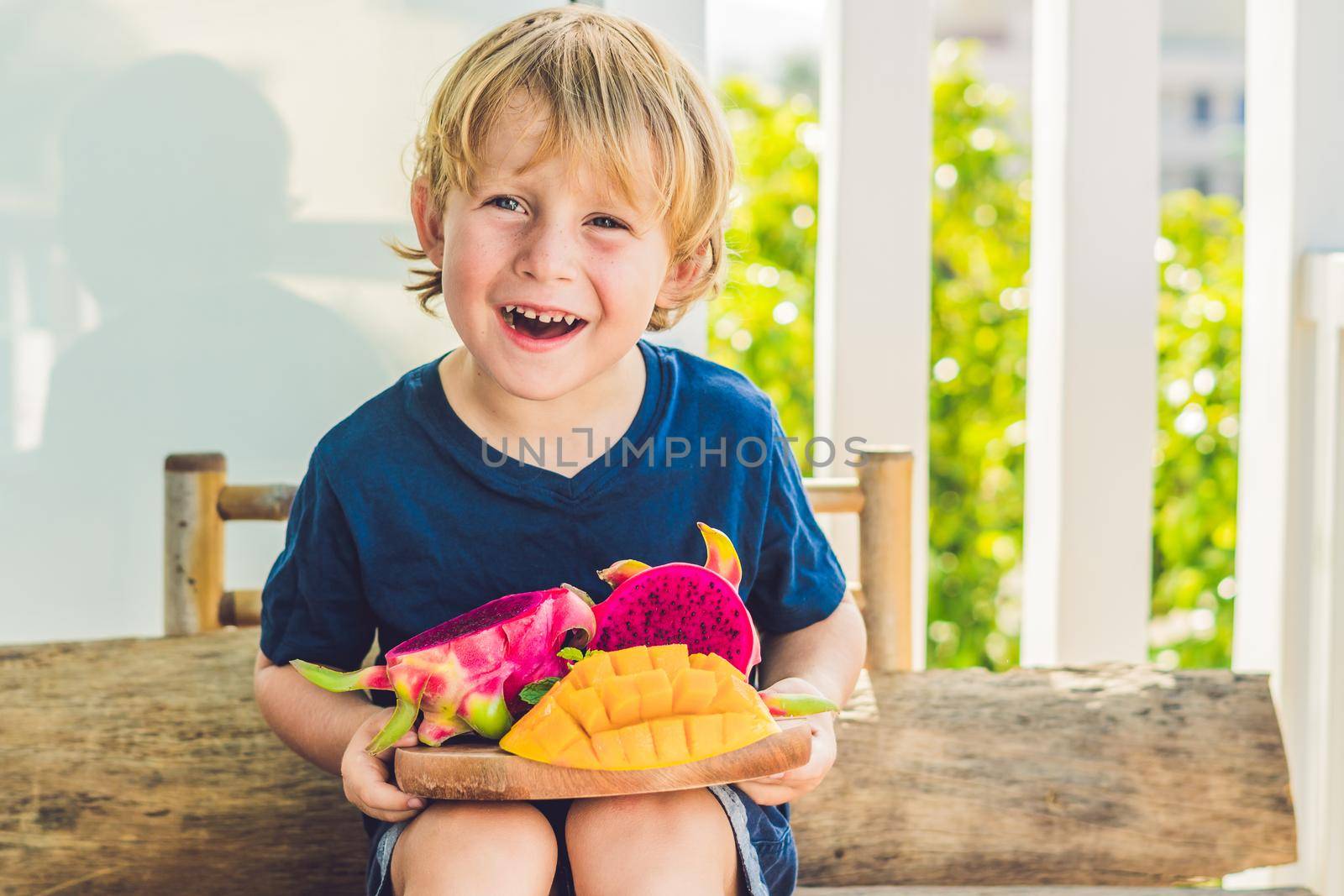 Diced dragon fruit and mango in the hands of the boy.