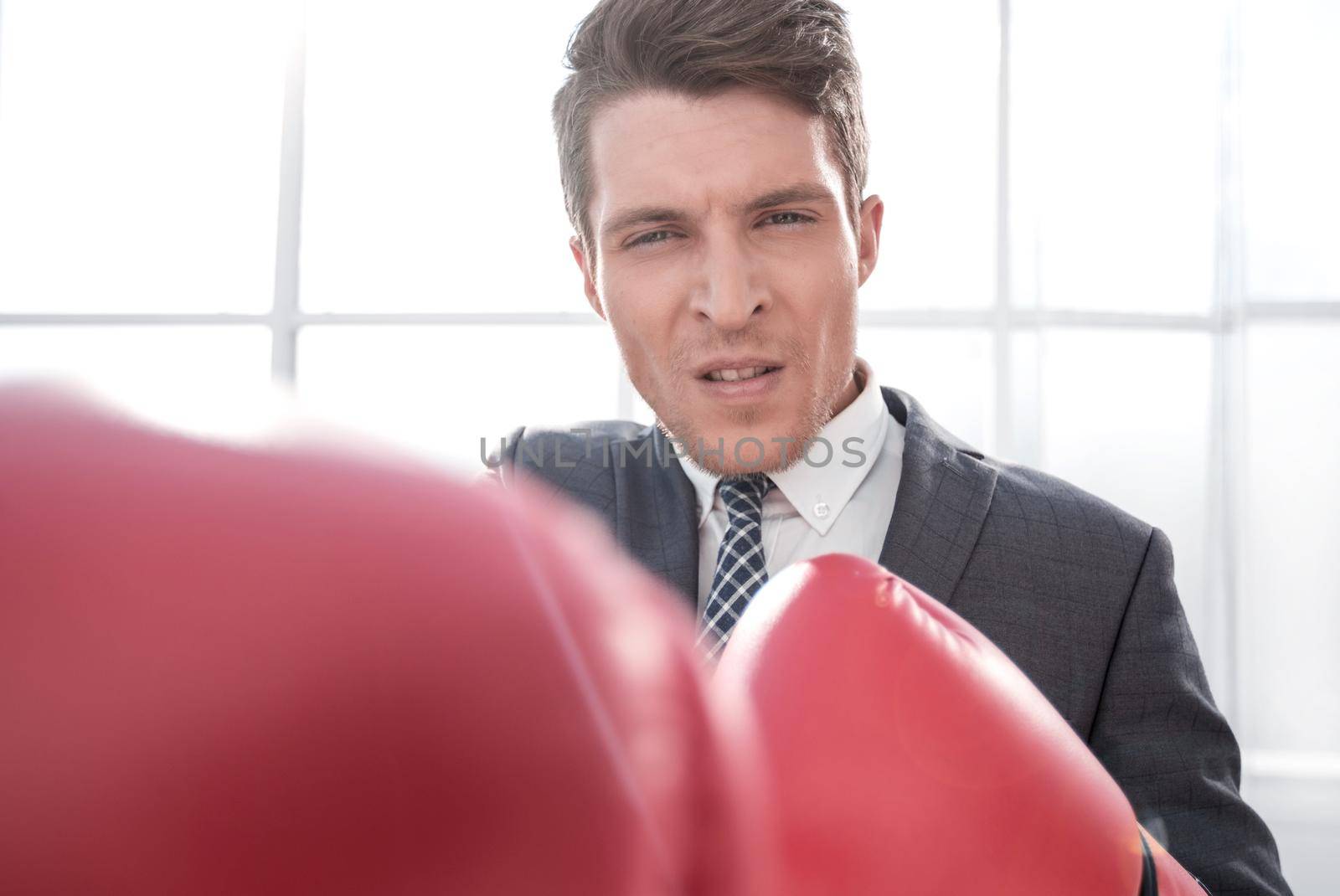 purposeful young businessman in Boxing gloves. concept of competitiveness