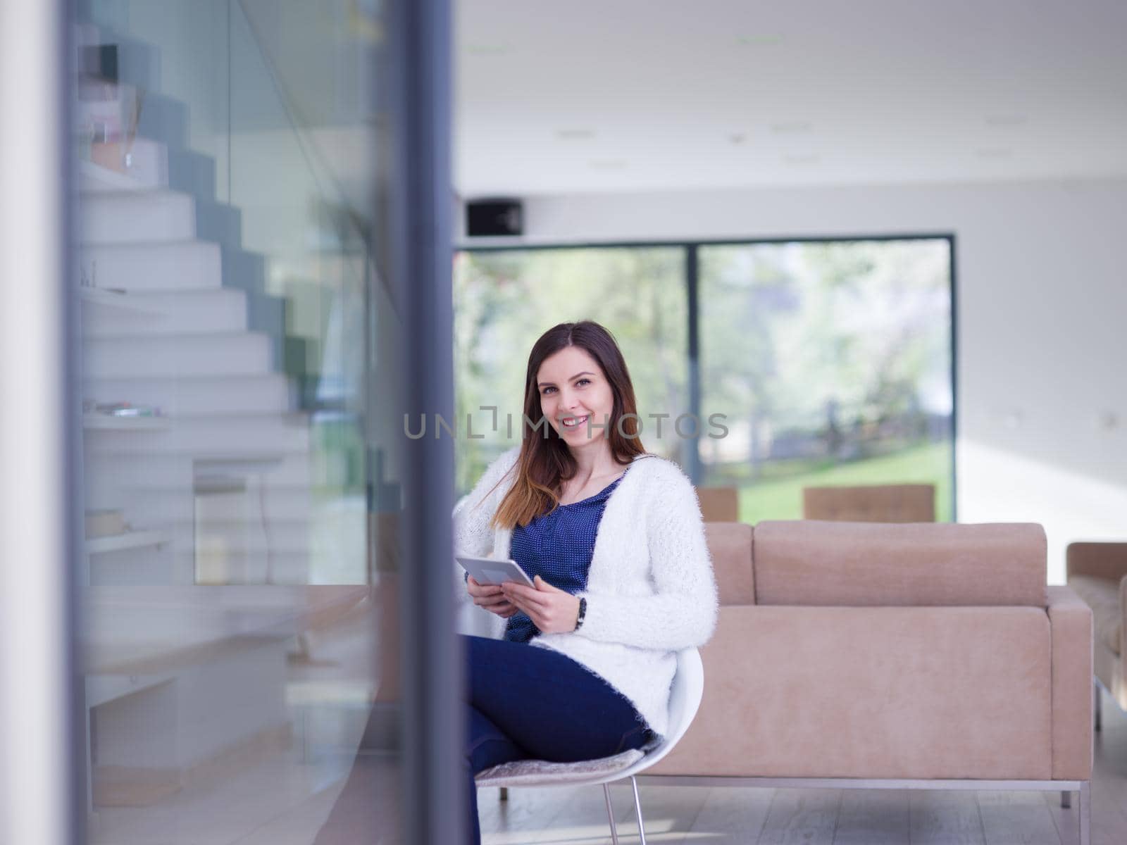 beautiful young women using tablet computer by the window  of her luxury home