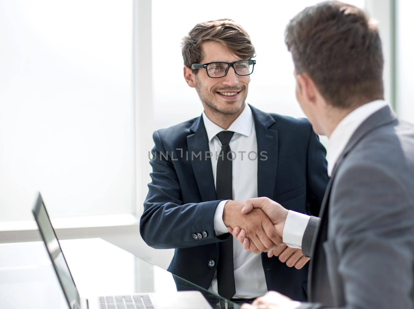 handshake business people sitting at the office Desk. by asdf